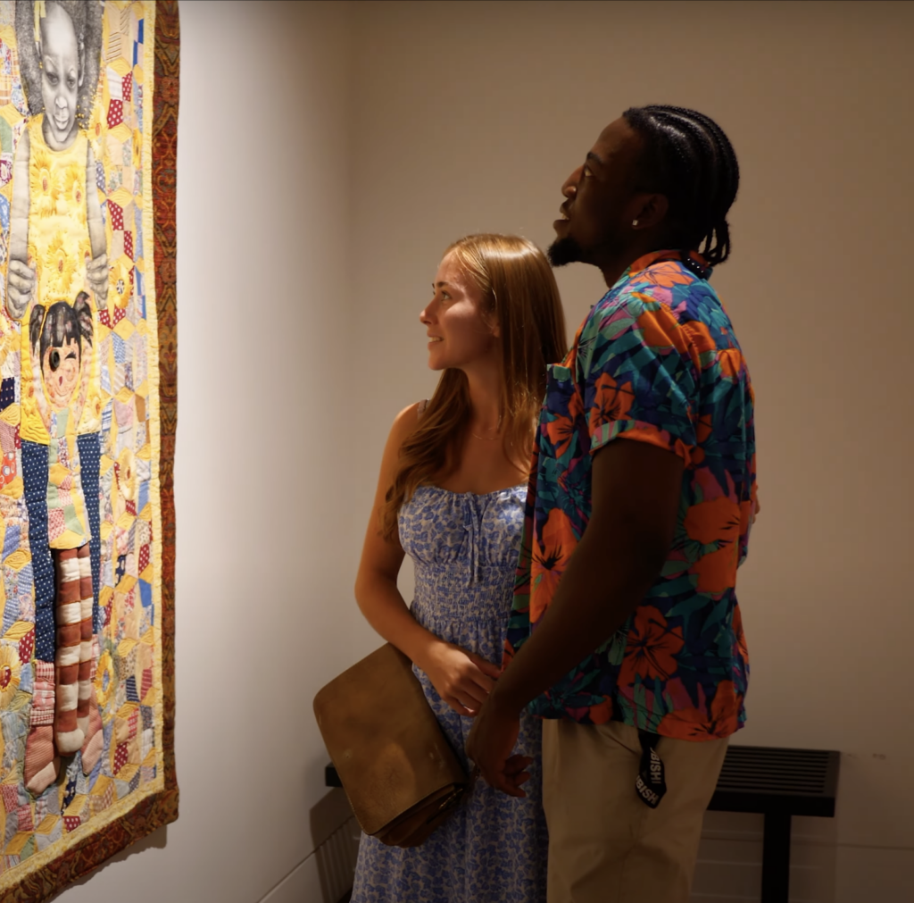 Two museum visitors viewing art on the wall